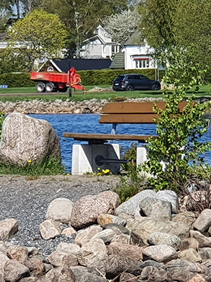 Park Bench nestled near a path walkway in a public park.